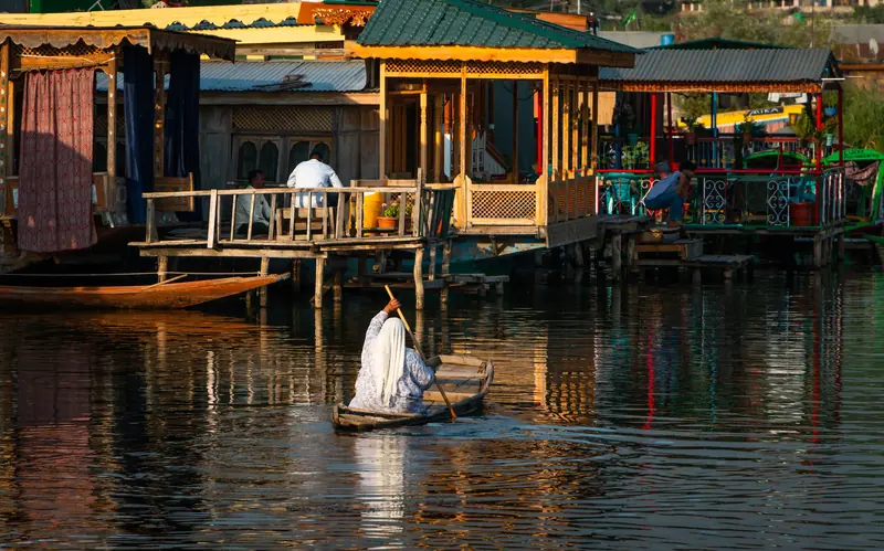 A shikara passing houseboats on Dal Lake